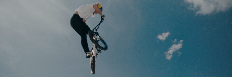 Standbild aus RB Leipzig – The Ultimate Jersey Journey. Ein BMX-Fahrer springt vor blauem Himmel in die Luft.