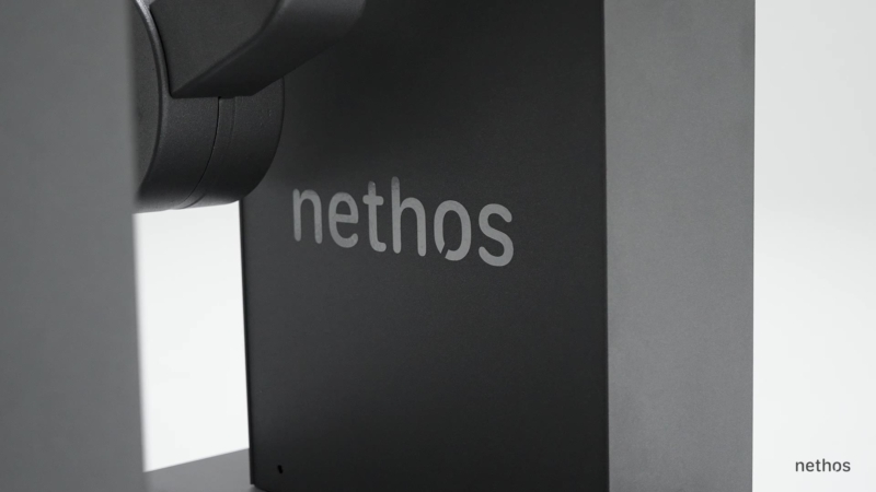 Standbild aus nethos. Der Schriftzug „nethos“ am Gerät in Nahaufnahme.